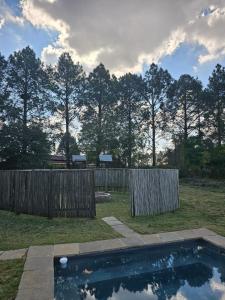 a swimming pool in a yard next to a wooden fence at Barnfires Farmhouse in Denysville