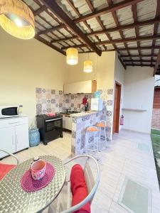 a kitchen and living room with a table and chairs at Chalé Nina in Areias