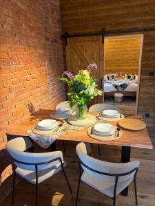 a wooden table with chairs and a vase of flowers at Apartmány CHATTA in Horní Maršov