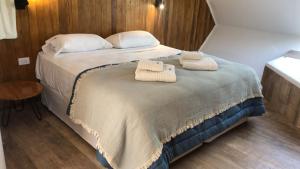a bedroom with a bed with two towels on it at Abismo Privado Cabaña de Lujo con Jacuzzi in San Rafael