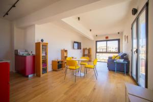 a living room with a table and yellow chairs at Solemar Sicilia - Torre Maqueda in Palermo
