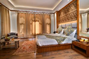 a bedroom with a large bed and a large window at The Forest Castle Resort in Pahalgām