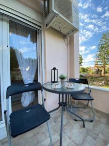 a patio with a table and two chairs and a microwave at MarSia Apartment in Chios