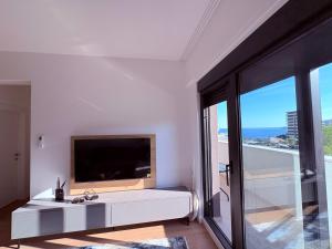 a white room with a television and a large window at Luxury 2BR Sea View & Garage & Twin Towers Becici in Bečići
