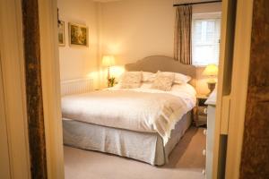 a bedroom with a bed with white sheets and pillows at Heathend in Petworth