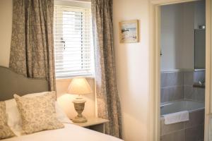 a bedroom with a bed and a bathroom with a tub at Heathend in Petworth