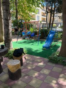 a playground with a slide in a park with trees at AMARA-BOUTIQUE & DESIGN - Студио in Ravda