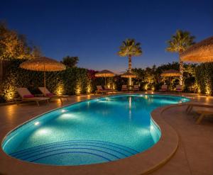 a swimming pool at night with umbrellas and chairs at Villa Joanna in Xagħra