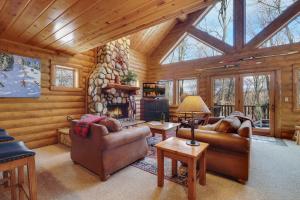 a living room with couches and a fireplace in a log cabin at 823 Mountain Cabin in Boyne Falls