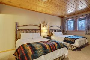 a bedroom with two beds and a wooden ceiling at 823 Mountain Cabin in Boyne Falls
