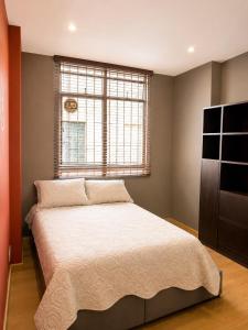 a bedroom with a large bed with a window at Casa Corferias in Bogotá