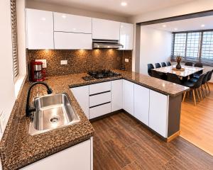 a kitchen with a sink and a dining room at Casa Corferias in Bogotá