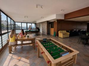 two women sitting in a room with a pool table at LRH Viña del Mar and Convention Center - Ex Gala Hotel in Viña del Mar