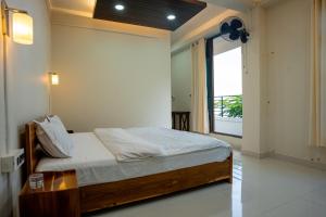 a bedroom with a bed and a large window at Seven Miles Hotel in Āīzawl
