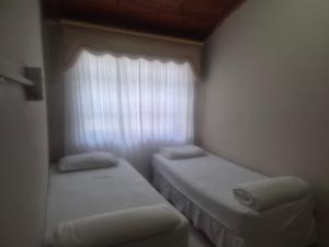 two beds in a small room with a window at Jack & Ace in Durban