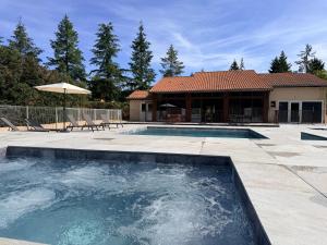 a swimming pool in front of a house at Le Moulin de Barette - Blavozy, 43700 Le Puy-en-Velay in Blavozy