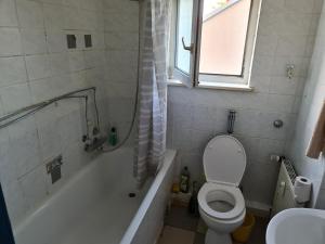a bathroom with a toilet and a tub and a sink at SCHLAFGELEGENHEiT in Essen