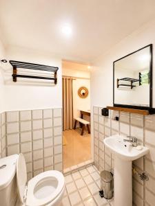 a bathroom with a toilet and a sink at A&H Homestay in Catangnan