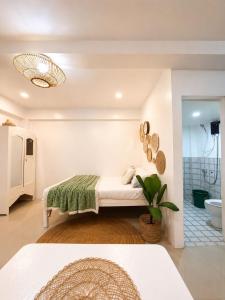 a white room with a bed and a bathroom at A&H Homestay in Catangnan