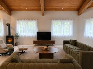 a living room with couches and a television and a table at Bachchalet im Schwarzwald in Sasbachwalden