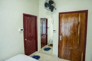 a room with two wooden doors and a mirror at Seven Miles Hotel in Āīzawl +71 photos