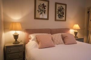 a bedroom with a bed with pillows and two lamps at Highfield in Petworth