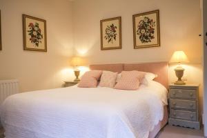 a bedroom with a large white bed with two lamps at Highfield in Petworth
