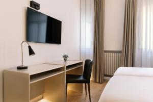 a hotel room with a desk and a bed at Hospedium Hotel Lleida in Graus