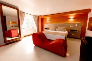 a bedroom with a bed and a red chair at Hostal Los Cactus in Lima