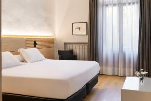 a hotel room with a bed and a desk at Hospedium Hotel Lleida in Graus
