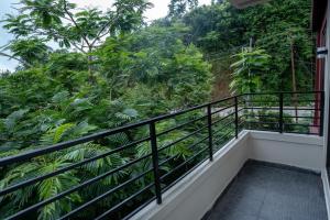 a balcony with a view of the jungle at Seven Miles Hotel in Āīzawl