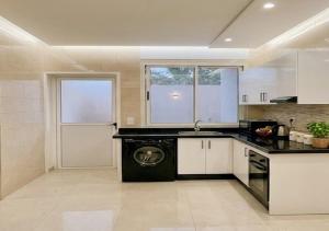 a kitchen with a sink and a dishwasher in it at Al Hoceima Luxury Residence Amina 3 in Al Hoceïma