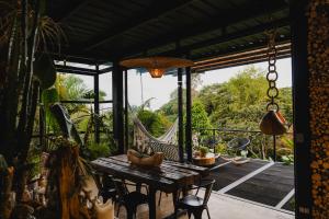 a patio with a table and chairs and a hammock at Element Quindío in Boquía