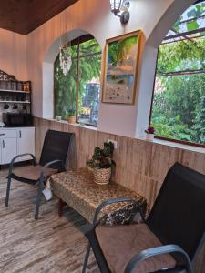 a room with a table and chairs and two windows at Kallithea in 2 Mai