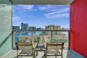 a balcony with a table and chairs and a view of the city at Charming Studio by the Ocean Beach Service in Hallandale Beach