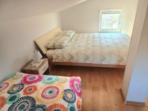 a small bedroom with a bed and a window at House Barizoni in Ankaran