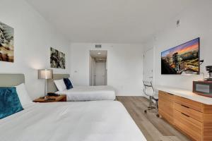 a hotel room with two beds and a tv at Charming Studio by the Ocean Beach Service in Hallandale Beach +39 photos