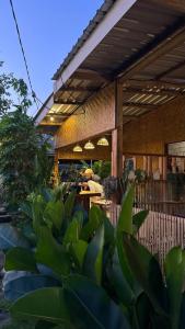 a group of people sitting at a table under a building at Local Garden Homestay in Masbagik