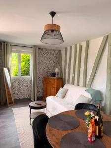 a living room with a bed and a table at La maisonnette in Forêt-la-Folie