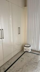 a kitchen with white cabinets and a scale on the floor at PR PREMIUMSUITs in Surūrnagar