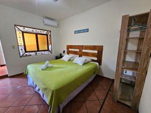 a bedroom with a green bed and a window at Villa Stahl in San Salvador