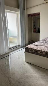 a bedroom with a bed and a large window at PR PREMIUMSUITs in Surūrnagar