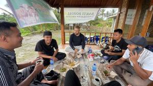 a group of men sitting around a table eating food at Local Garden Homestay in Masbagik +30 photos