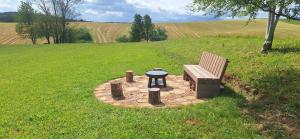 a bench and a table in the middle of a field at Cube Hills in Rakovica