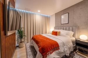 a bedroom with a large bed with an orange blanket at Riomaggiore City Tower in Cali