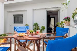 a table with a plate of food and blue chairs at The Hidden Gem Skopelos - Elegant Island Retreat in Skopelos Town