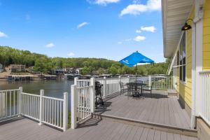 a deck with a table and a blue umbrella at Coconuts RV Resort in Gravois Mills