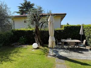 a patio with a table and an umbrella and a table and chairs at Appartamenti HERA in Lazise