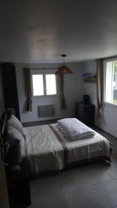 a bedroom with a bed and two windows at Pinede in Labenne
