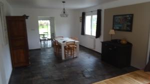 a living room with a table and a dining room at Pinede in Labenne